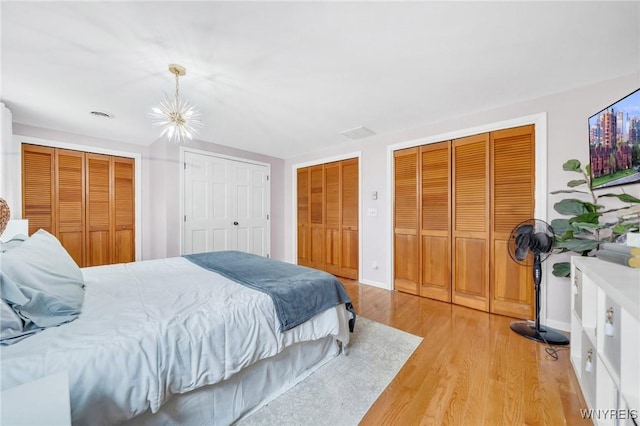 6317 Tonawanda Creek Rd, Lockport-Town, NY 14094 - bedroom featuring a chandelier, multiple closets, and light wood-type flooring