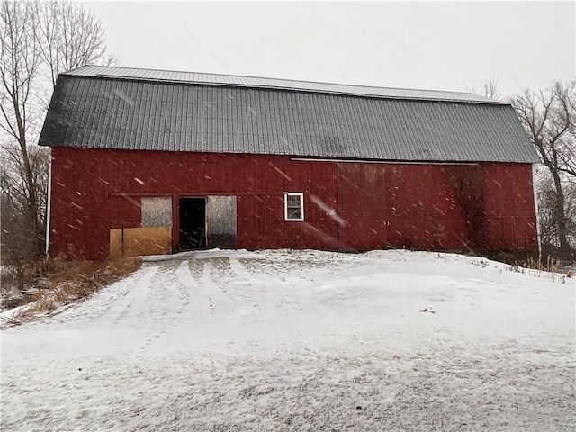 snow covered structure with an outbuilding and a barn