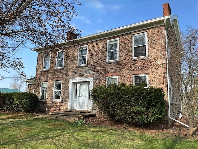 view of front facade with a front lawn and a chimney