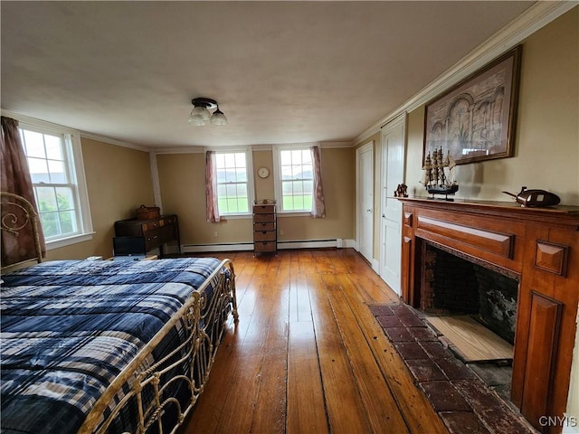 bedroom featuring a fireplace with flush hearth, ornamental molding, a baseboard radiator, and wood-type flooring
