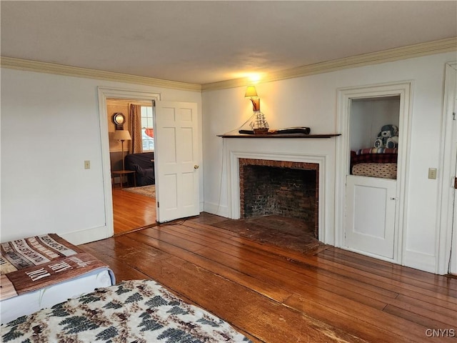 living room with a fireplace with flush hearth, hardwood / wood-style floors, baseboards, and ornamental molding