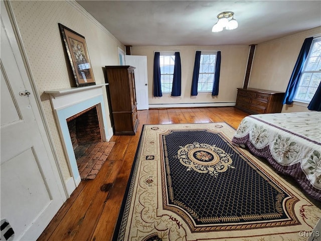 bedroom with hardwood / wood-style floors, ornamental molding, a baseboard radiator, and multiple windows