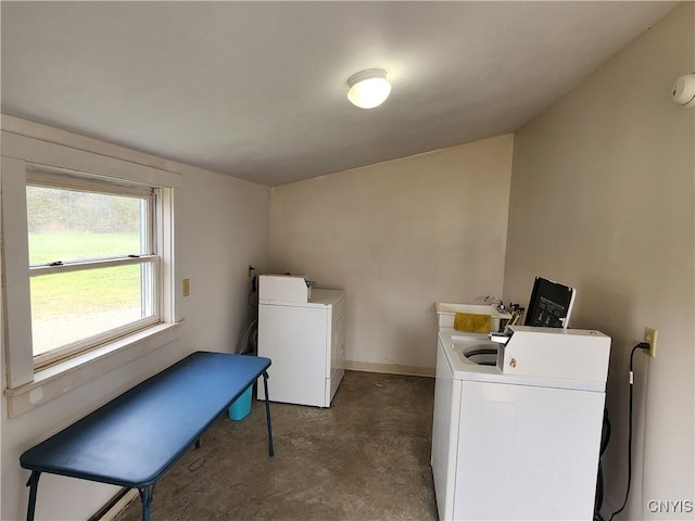 laundry area featuring washer and dryer, baseboards, and a sink