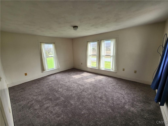 spare room with baseboards and carpet floors