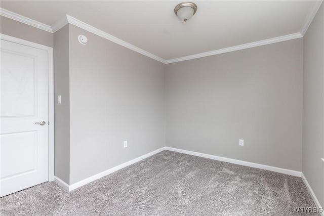 carpeted spare room featuring baseboards and ornamental molding