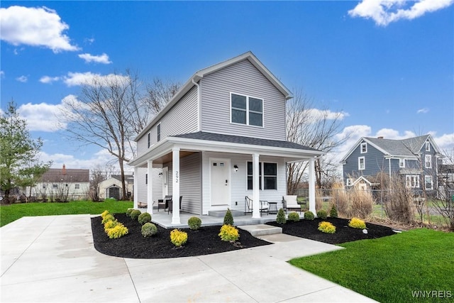 view of front of property featuring fence, a front lawn, and covered porch