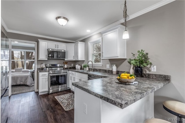 kitchen featuring a sink, crown molding, a peninsula, appliances with stainless steel finishes, and white cabinetry