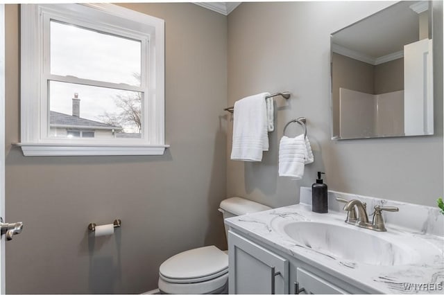 bathroom featuring toilet, ornamental molding, and vanity