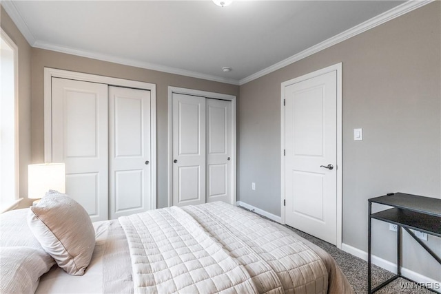 carpeted bedroom featuring two closets, crown molding, and baseboards