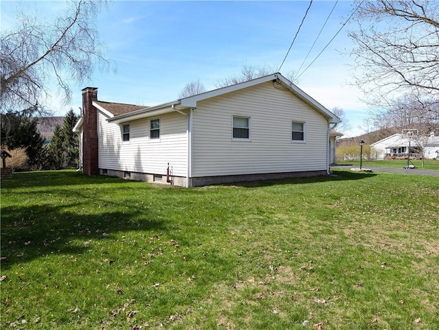 view of property exterior featuring a chimney and a yard