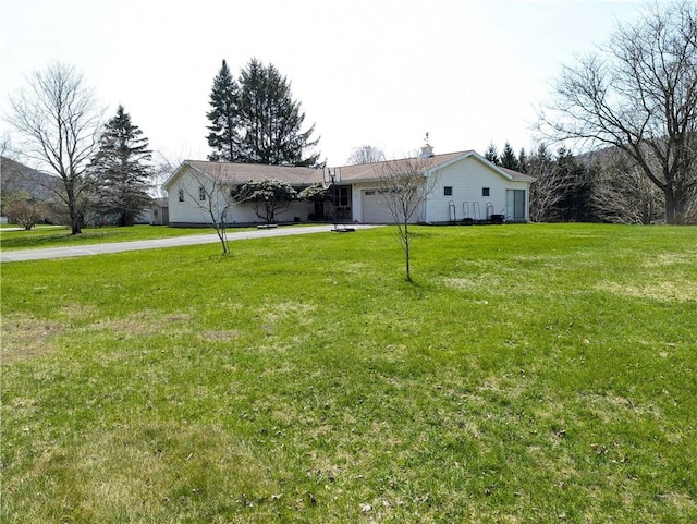 single story home with an attached garage, driveway, and a front lawn