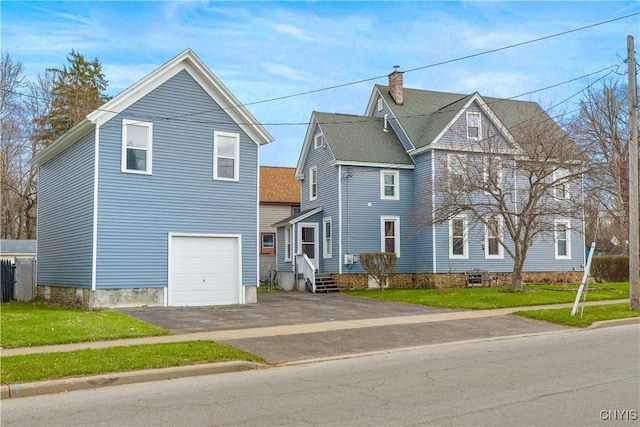 601 W Thomas St, Rome-Inside, NY 13440 - view of front of house with a front lawn, an attached garage, a chimney, and aphalt driveway