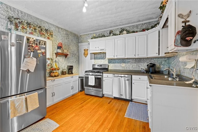 601 W Thomas St, Rome-Inside, NY 13440 - kitchen featuring under cabinet range hood, stainless steel appliances, a sink, light wood-style flooring, and white cabinetry