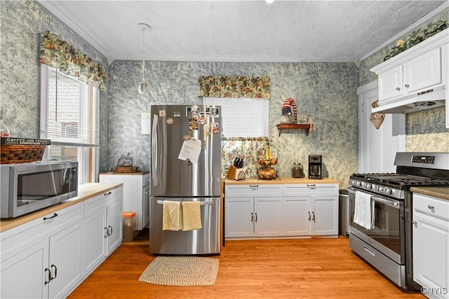 601 W Thomas St, Rome-Inside, NY 13440 - kitchen with wallpapered walls, under cabinet range hood, light wood-style floors, and stainless steel appliances