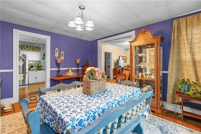 601 W Thomas St, Rome-Inside, NY 13440 - dining area with baseboards, wood finished floors, a chandelier, and a drop ceiling
