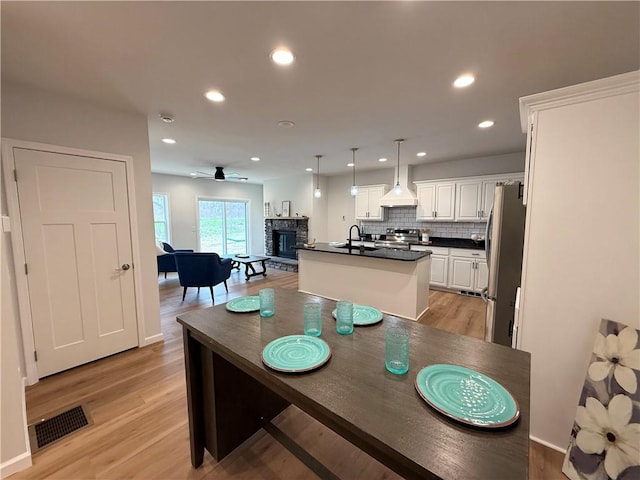 2002 Maes Lndg, Canandaigua-Town, NY 14424 - dining room with a ceiling fan, light wood-type flooring, a fireplace, visible vents, and recessed lighting