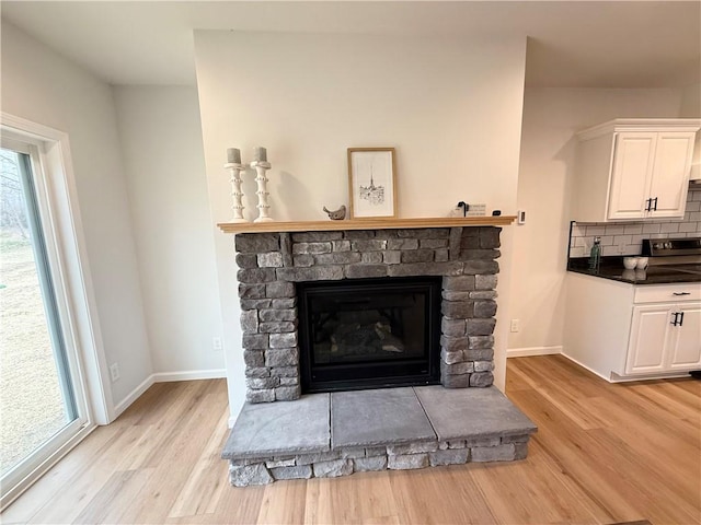 2002 Maes Lndg, Canandaigua-Town, NY 14424 - room details with decorative backsplash, a stone fireplace, wood finished floors, and baseboards