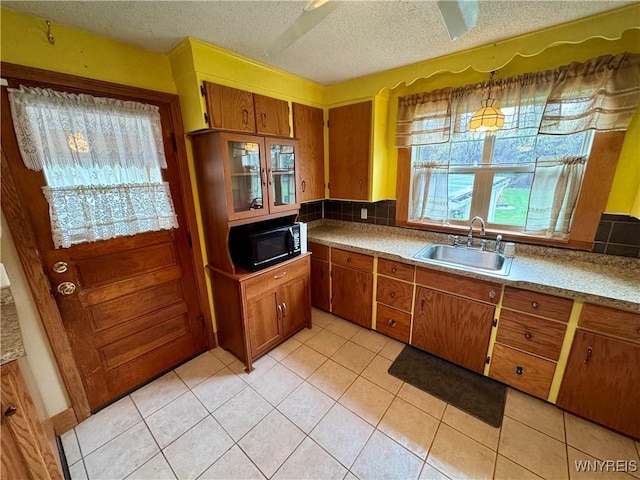 1432 Quaker Rd, Somerset, NY 14012 - kitchen with brown cabinets, light countertops, a sink, light tile patterned flooring, and black microwave