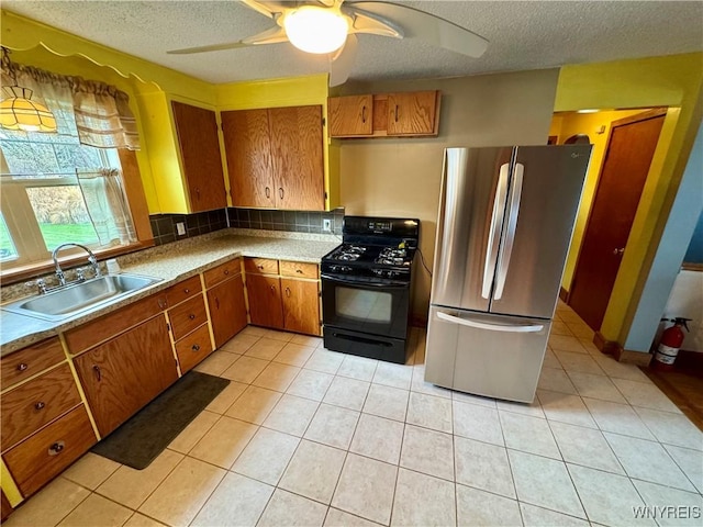 1432 Quaker Rd, Somerset, NY 14012 - kitchen featuring a textured ceiling, a sink, freestanding refrigerator, brown cabinets, and black range with gas cooktop
