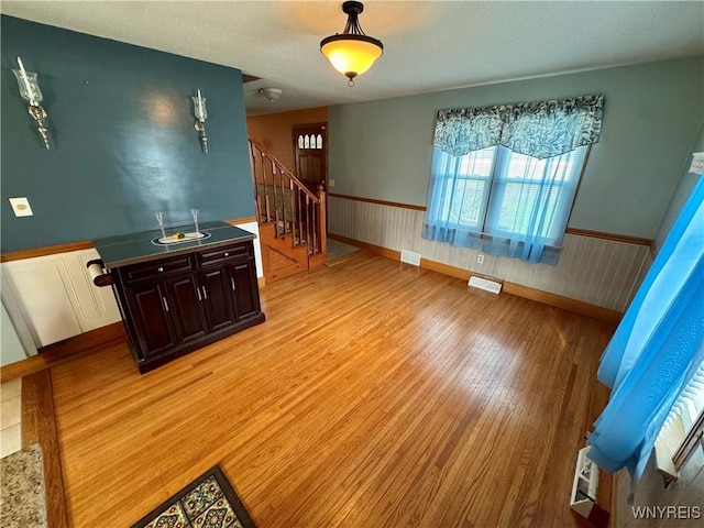 1432 Quaker Rd, Somerset, NY 14012 - interior space with stairway, a wainscoted wall, visible vents, and light wood-type flooring