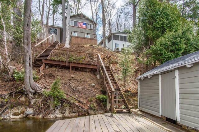 back of house featuring a wooden deck and stairs