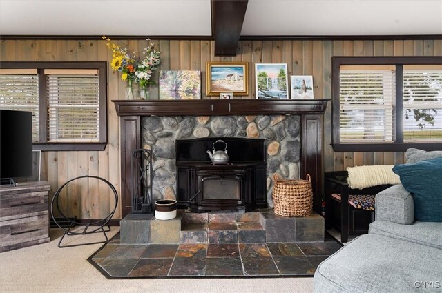room details featuring beam ceiling, wooden walls, and a fireplace