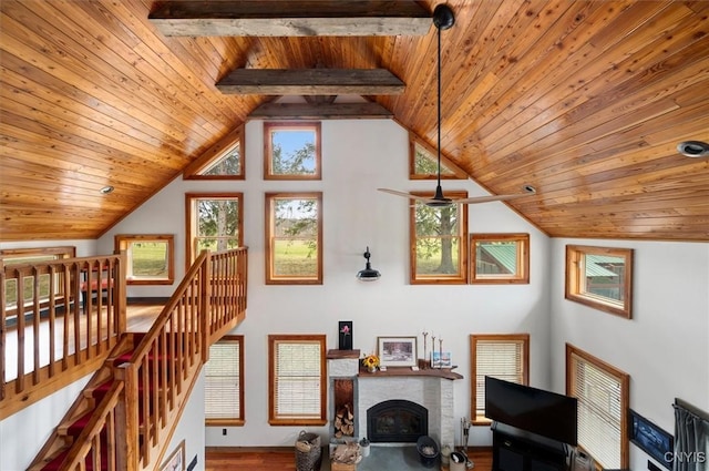 living area featuring lofted ceiling, wooden ceiling, wood finished floors, and a brick fireplace