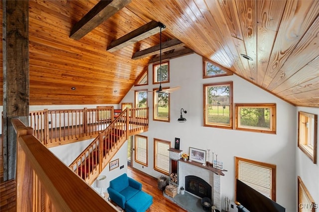 interior space featuring wood finished floors, a brick fireplace, lofted ceiling, and wood ceiling