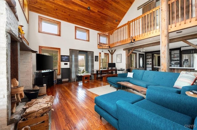 living room with high vaulted ceiling, wood-type flooring, and a fireplace