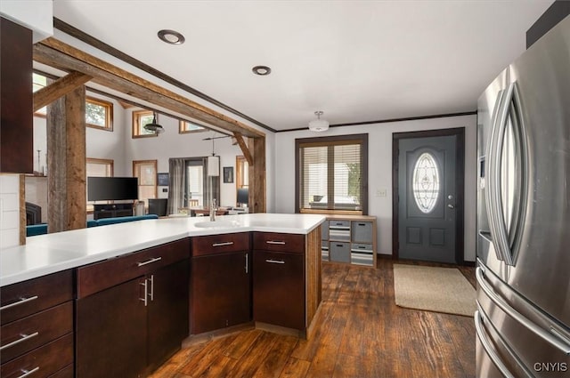 kitchen with stainless steel refrigerator with ice dispenser, light countertops, dark wood-style floors, and a sink