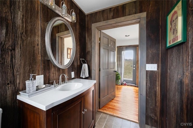bathroom with vanity and wooden walls