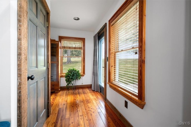 doorway featuring baseboards and light wood-type flooring