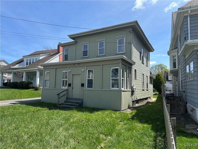 view of front of home with entry steps and a front lawn