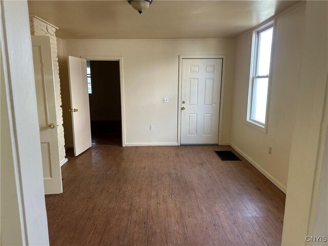 interior space with baseboards, wood finished floors, and visible vents