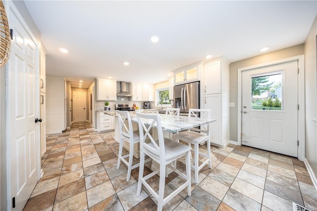 dining area featuring baseboards, stone tile floors, visible vents, and recessed lighting