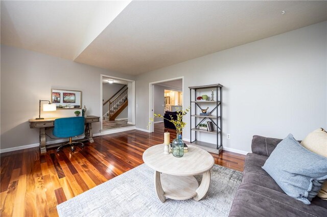 living area with wood finished floors, stairs, and baseboards
