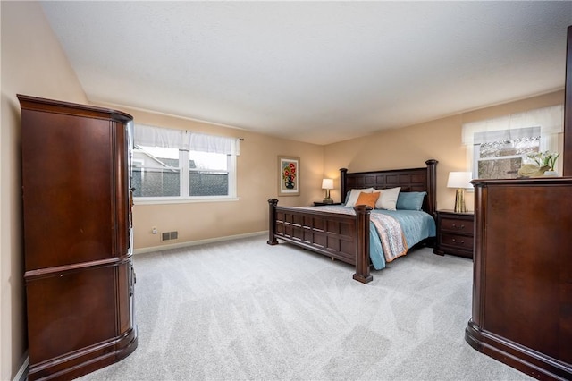 bedroom featuring visible vents, baseboards, and light carpet