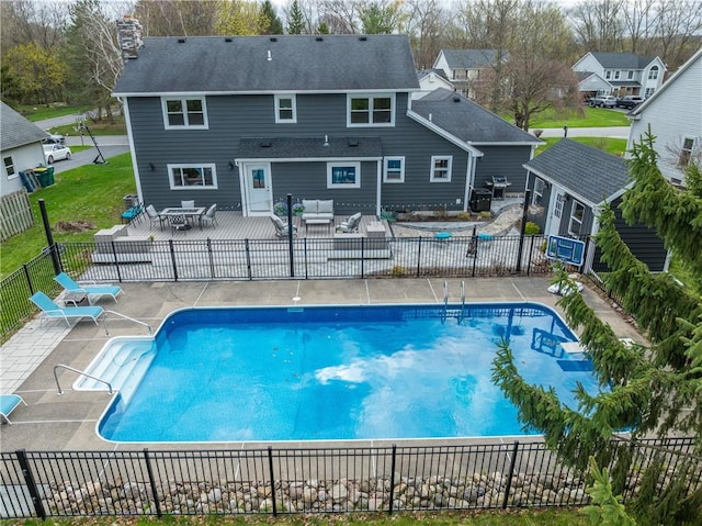 view of swimming pool with an outdoor living space, a fenced backyard, a fenced in pool, and a patio