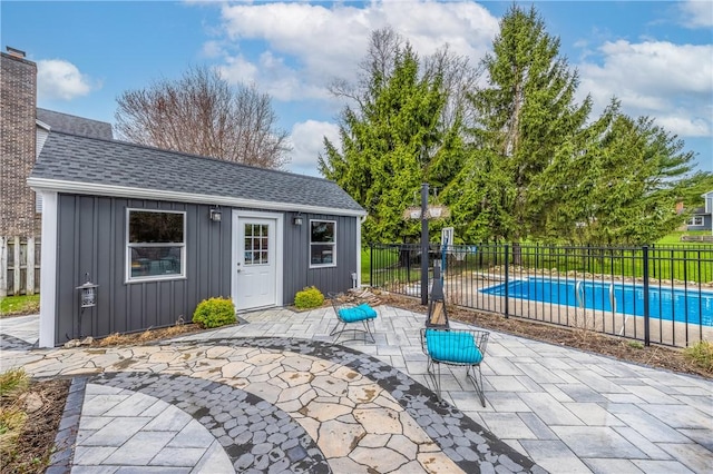 view of patio with an outdoor structure, fence, and a fenced in pool