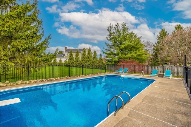 view of swimming pool featuring a fenced in pool, a patio, fence, and a diving board