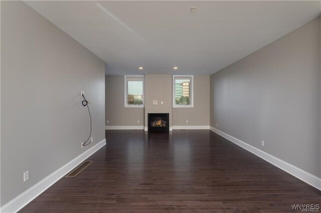 35 Ojibwa Cir, Buffalo, NY 14202 - unfurnished living room featuring dark wood-style floors, a glass covered fireplace, baseboards, visible vents, and recessed lighting