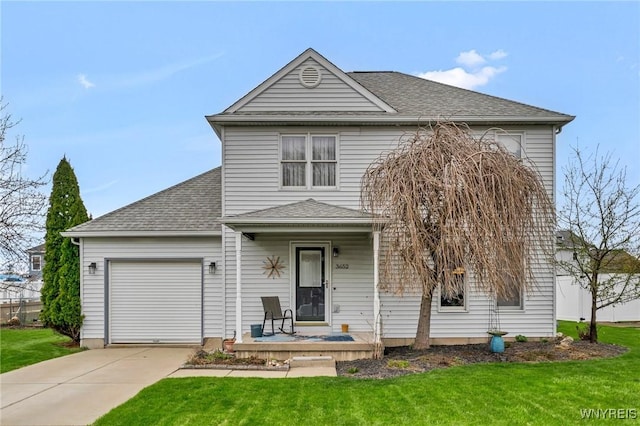 traditional-style house with concrete driveway, an attached garage, a shingled roof, and a front yard