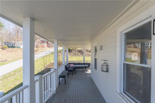 wooden terrace with outdoor lounge area and a porch