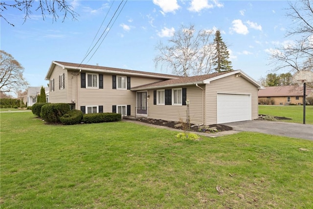 tri-level home featuring an attached garage, aphalt driveway, and a front yard