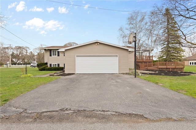 view of front of property featuring a garage, a front lawn, aphalt driveway, and a deck