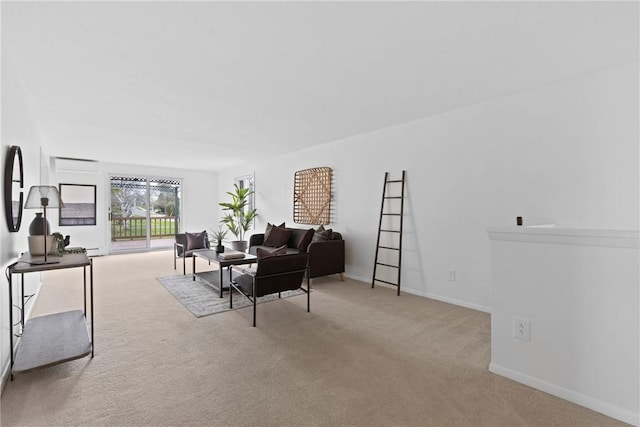 carpeted living area featuring baseboards and a wall mounted air conditioner