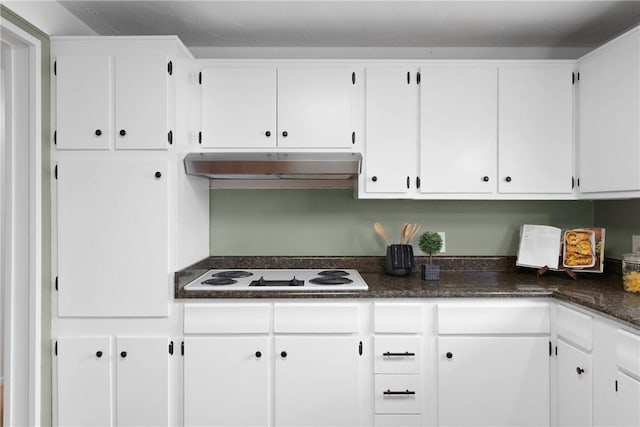 kitchen with white cabinets, dark countertops, white electric cooktop, and under cabinet range hood