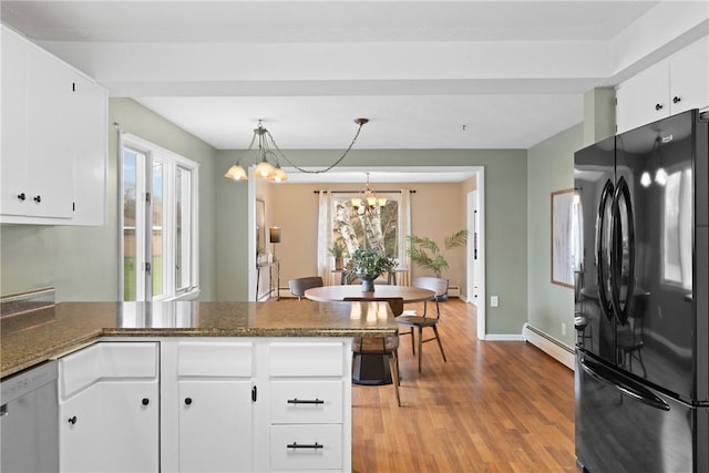 kitchen featuring a baseboard heating unit, a chandelier, dishwasher, a peninsula, and freestanding refrigerator