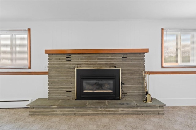 room details featuring a fireplace, carpet, crown molding, and baseboard heating