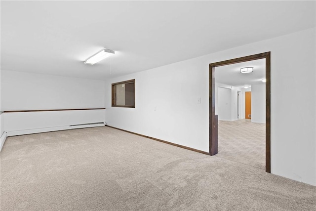 carpeted empty room with a baseboard heating unit and baseboards